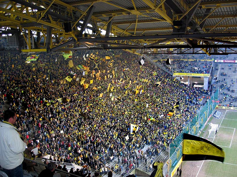 Suedtribuene Dortmund. Foto aus Wikipedia: Artikel Dortmund, Beschreibung: Südtribüne des Westfalenstadion in Dortmund. Mit einer Kapazität von ca. 25000 die größte Stehplatztribüne Europas. Author: Pascal Philp. Überarbeitete Version von Benutzer LSDSL: http://commons.wikimedia.org/w/index.php?title=File:Suedtribuene.jpg&oldid=50165946&uselang=de. Diese Datei ist unter der Creative Commons-Lizenz Namensnennung-Weitergabe unter gleichen Bedingungen 2.0 Deutschland lizenziert: http://creativecommons.org/licenses/by-sa/2.0/de/deed.de